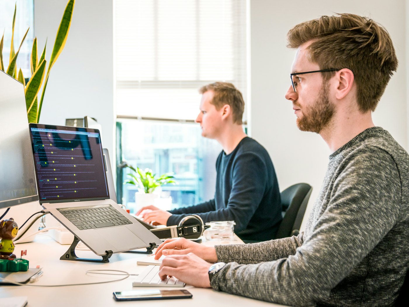 Two colleagues working at their desks in a bright office