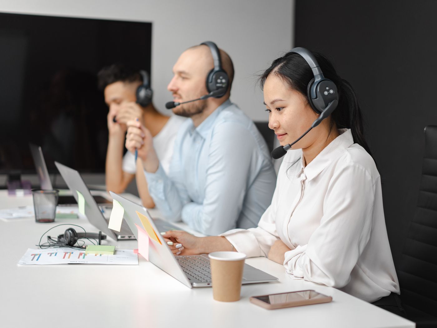Support team members on calls at their desks in the office